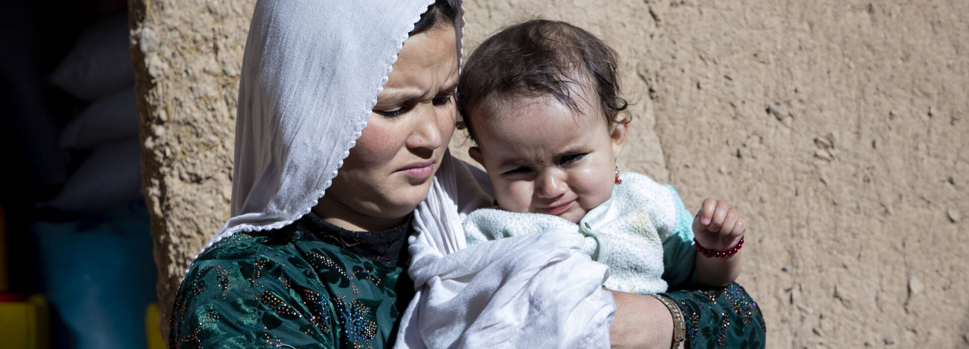 Mutter aus Afghanistan hält ihr Kind auf dem Arm