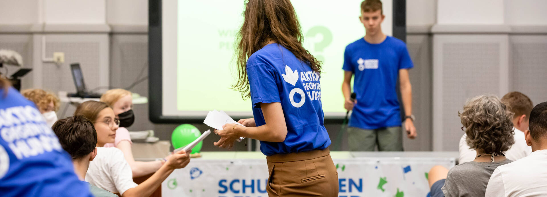 Ein Bildungsvortrag von Schulen gegen den Hunger Ein Bildungsvortrag von Schulen gegen den Hunger: Mitarbeiter*innen verteilen Materialien und zeigen eine interaktive Präsentation.