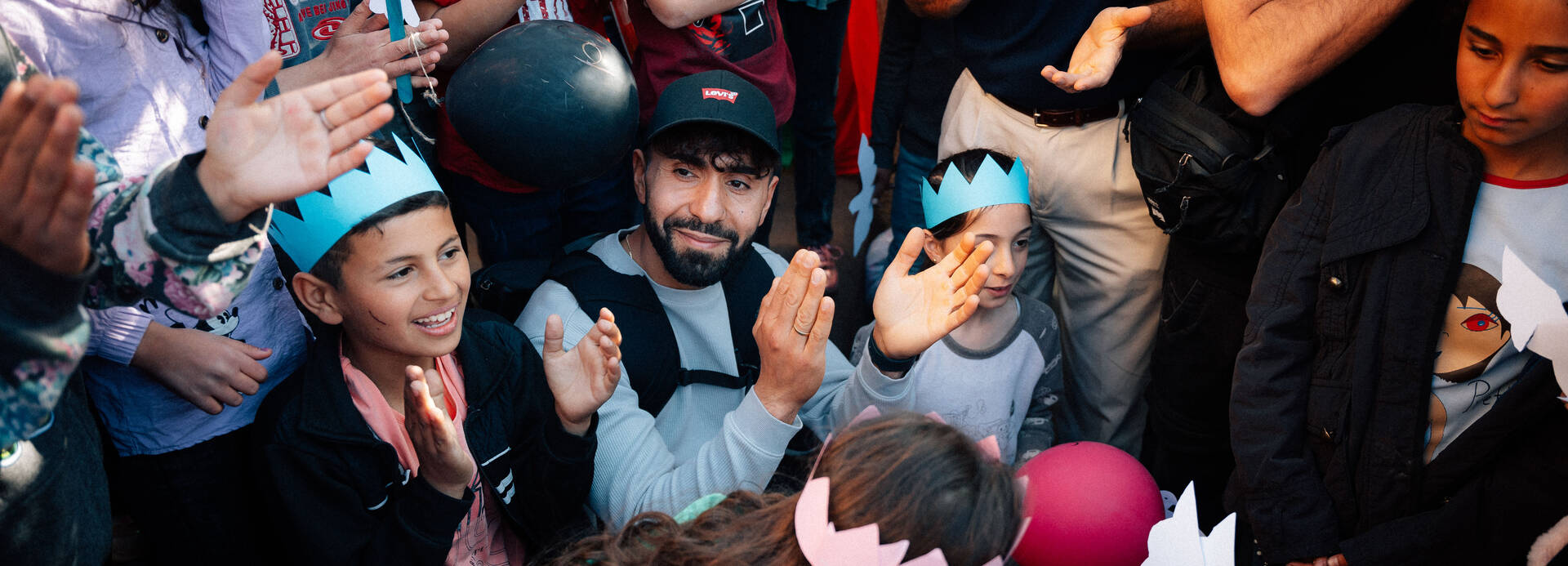 Kinder aus dem Libanon mit Papierkronen und Friedenstauben, zusammen mit Rapper Motrip Kinder aus dem Libanon mit Papierkronen und Friedenstauben, zusammen mit Rapper Motrip