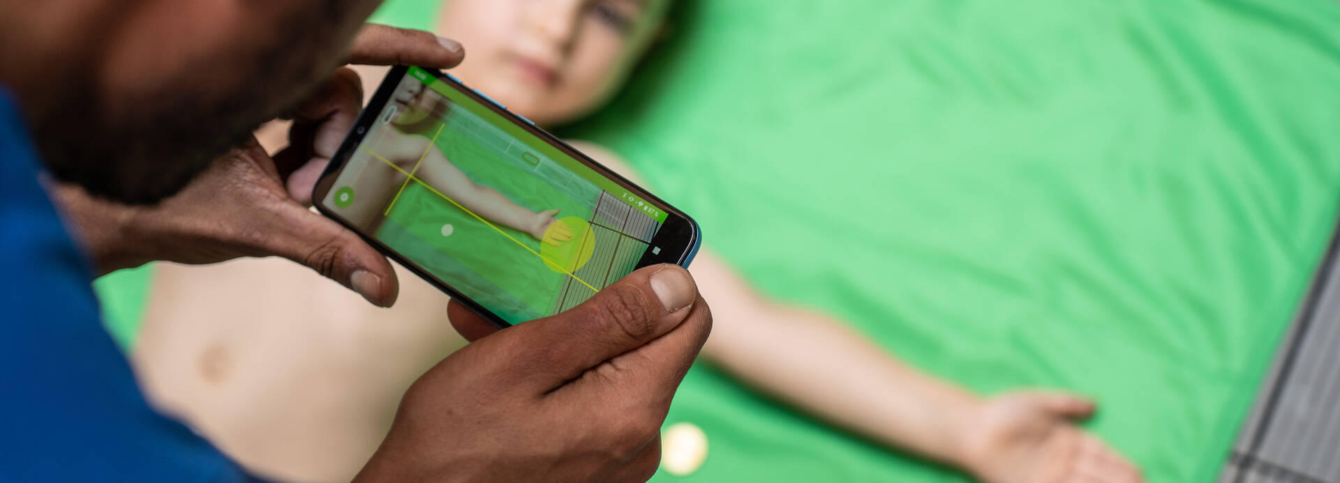 Ein Mitarbeiter von Aktion gegen den Hunger testet die SAM Photo-App mit der Unterstützung eines Jungen. Ein Mitarbeiter von Aktion gegen den Hunger testet die SAM Photo-App mit der Unterstützung eines Jungen.