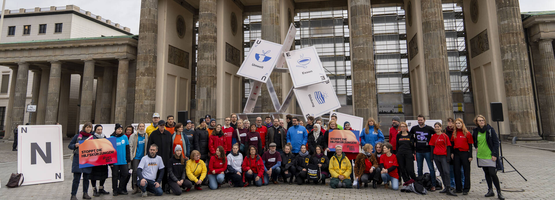 Mitglieder von Hilfsorganisationen bei der Protestaktion #Luftnachoben vor dem Brandenburger Tor in Berlin, im Hintergrund ein zusammenfallendes Kartenhaus. Mitglieder von Hilfsorganisationen bei der Protestaktion #Luftnachoben vor dem Brandenburger Tor in Berlin, im Hintergrund ein zusammenfallendes Kartenhaus.
