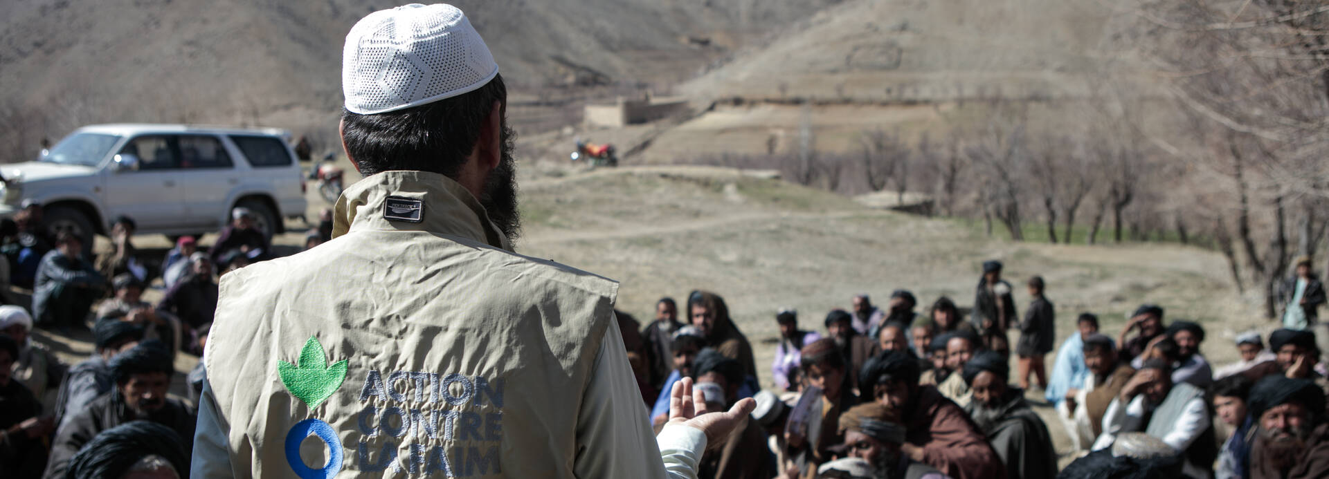 Ein Mitarbeiter von Aktion gegen den Hunger spricht vor einer Menschengruppe in Afghanistan. Ein Mitarbeiter von Aktion gegen den Hunger spricht vor einer Menschengruppe in Afghanistan.