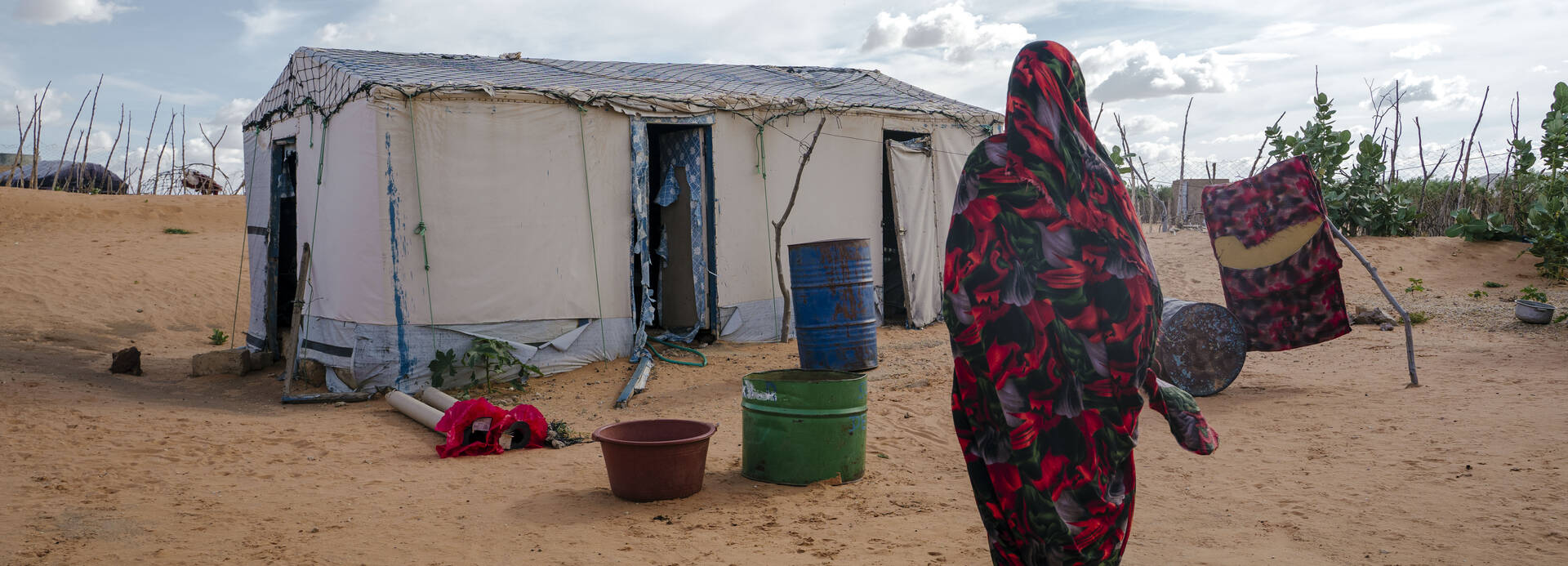 Eine Frau im Flüchtlingscamp Mbera in Mauretanien auf dem Weg zu ihrer Unterkunft. Eine Frau im Flüchtlingscamp Mbera in Mauretanien auf dem Weg zu ihrer Unterkunft.