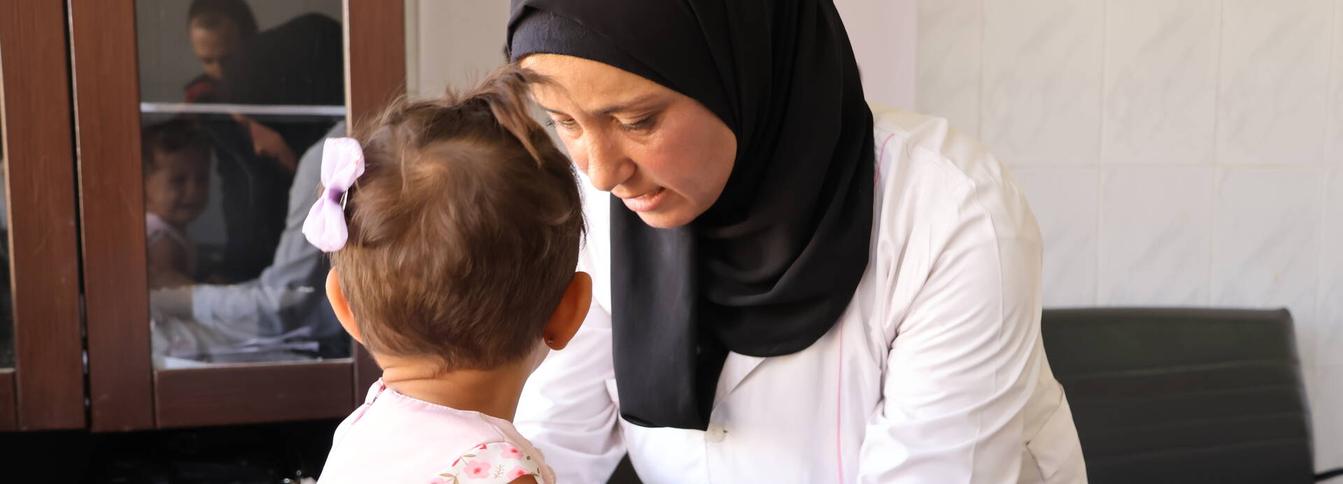 Eine Gesundheitshelferin in unseren mobilen Kliniken in Syrien untersucht ein Kleinkind. Eine Gesundheitshelferin in unseren mobilen Kliniken in Syrien untersucht ein Kleinkind.