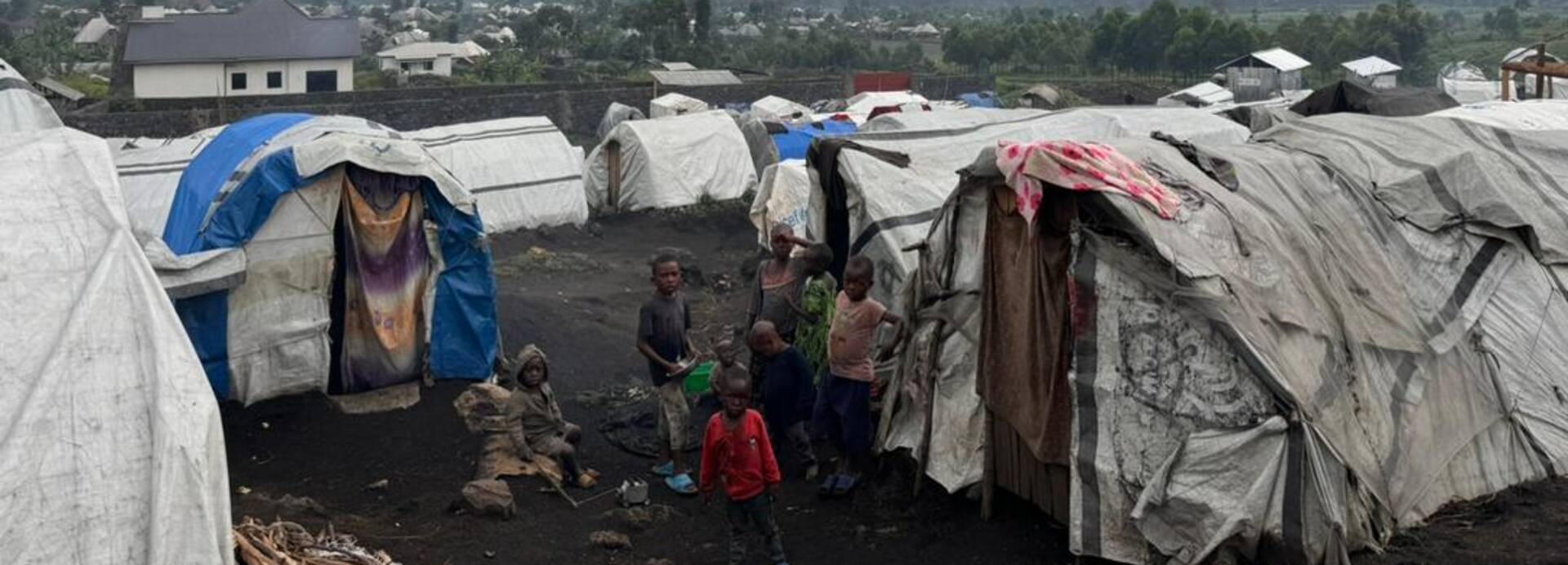Ein Ausschnitt eines Vertriebenenlagers in der Nähe von Goma in der Demokratischen Republik Kongo. Ein Ausschnitt eines Vertriebenenlagers in der Nähe von Goma in der Demokratischen Republik Kongo. In der Mitte ist eine Familie zwischen Zelten zu sehen.