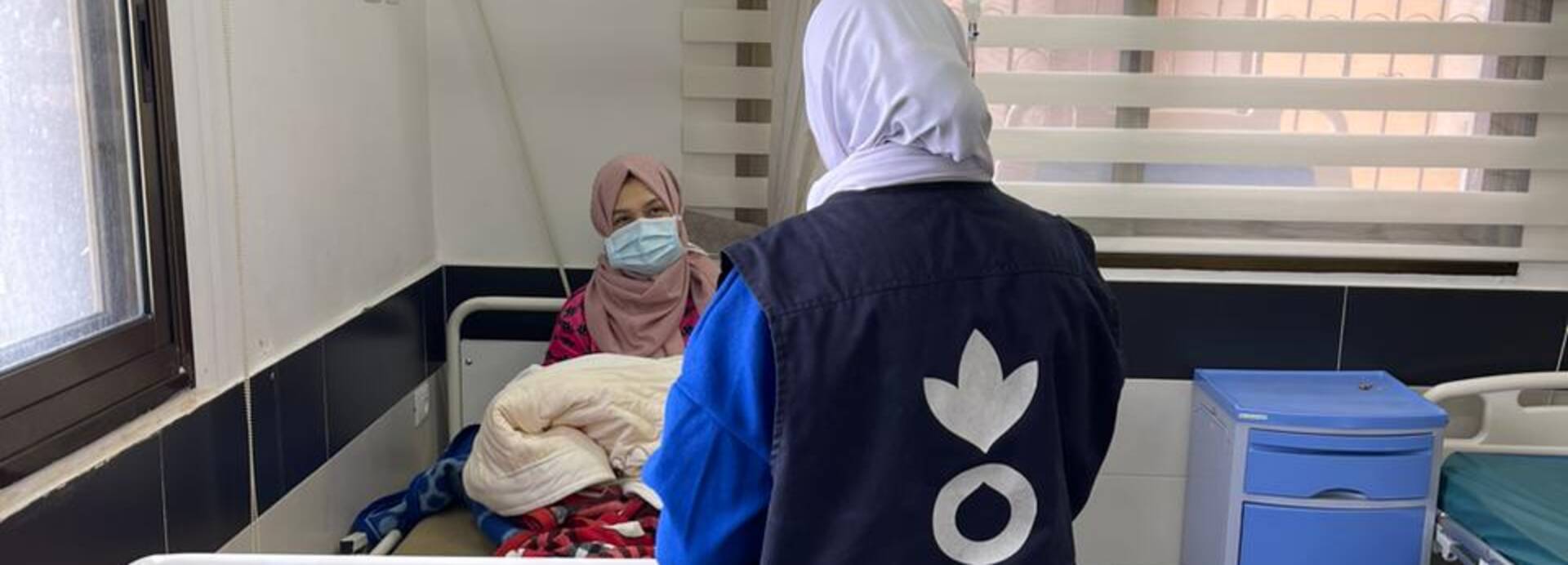 Eine Mitarbeiterin von Aktion gegen den Hunger spricht mit einer jungen Mutter im Al Awda Krankenhaus in Jabalia, Gaza Eine Mitarbeiterin von Aktion gegen den Hunger spricht mit einer jungen Mutter im Al Awda Krankenhaus in Jabalia, Gaza