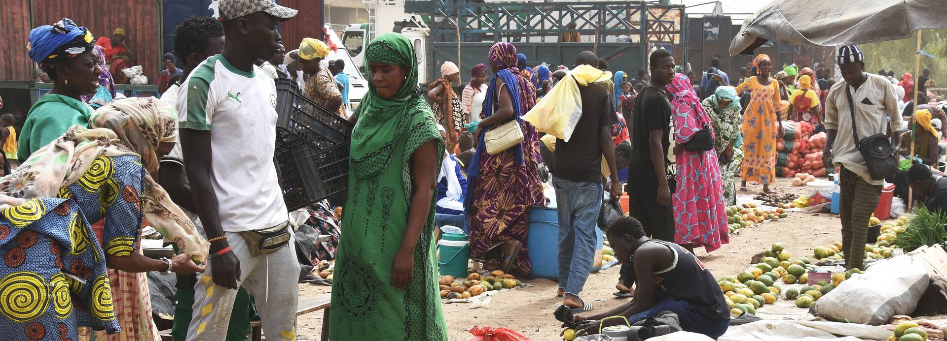 Ein Markt im Senegal, im Vordergrund Früchte, viele Menschen sind anwesend. Ein Markt im Senegal, im Vordergrund Früchte, viele Menschen sind anwesend.