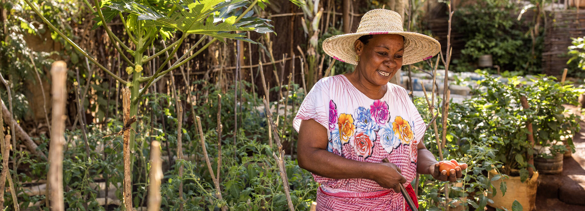 Salama Madinda in ihrem Gemüsegarten Salama Madinda steht lächelnd in ihrem Gemüsegarten