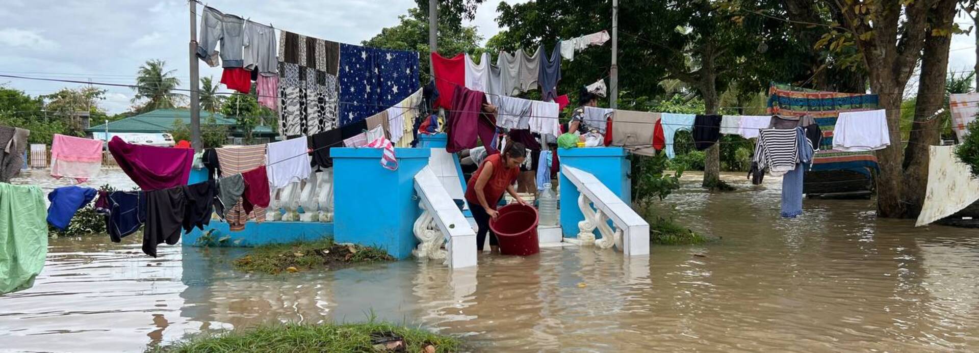 Der Tropensturm Trami hat auf den Philippinen Überschwemmungen ausgelöst. Eine Frau hat inmitten der Fluten nach dem Sturm Trami Wäsche aufgehangen.
