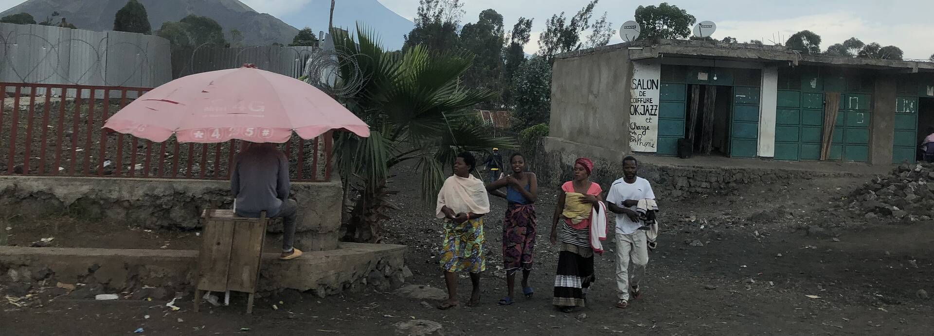 Vier Personen laufen durch ein Camp für Vertriebene Vier Personen laufen durch ein Camp für Vertriebene in der Demokratischen Republik Kongo