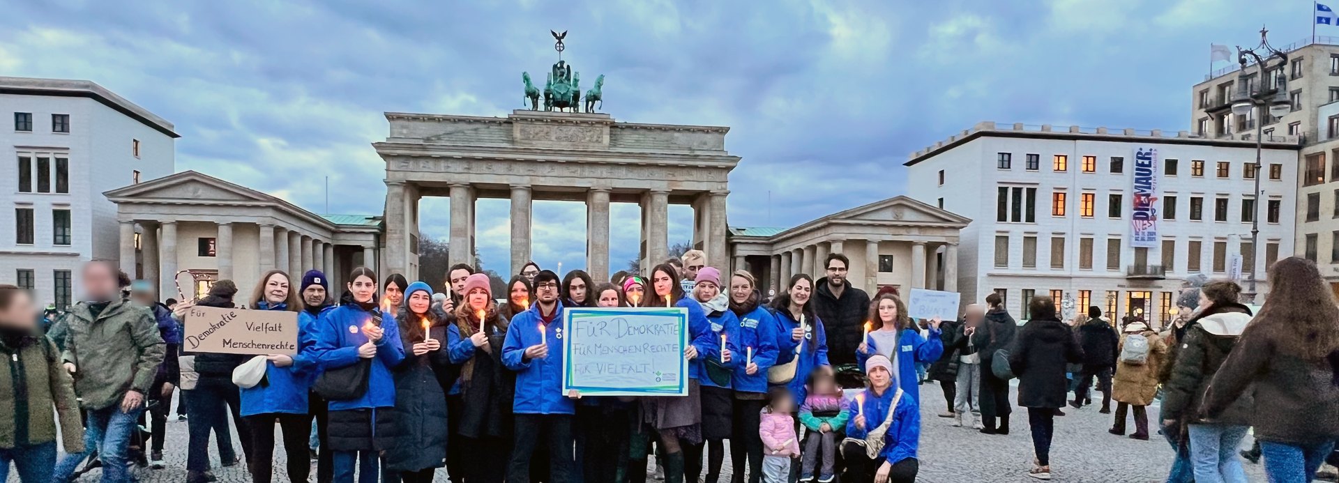 Mitarbeitende von Aktion gegen den Hunger vor dem Brandenburger Tor Mitarbeitende von Aktion gegen den Hunger stehen mit Schildern für Demokratie und Menschenrechte vor dem Brandenburger Tor.