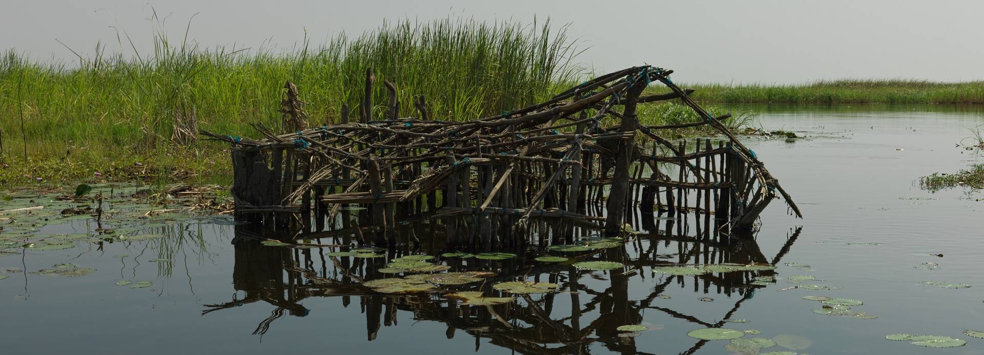 Überreste eines Hauses aus Holz ragen aus dem Wasser in einem Überschwemmungsgebiet im Südsudan.