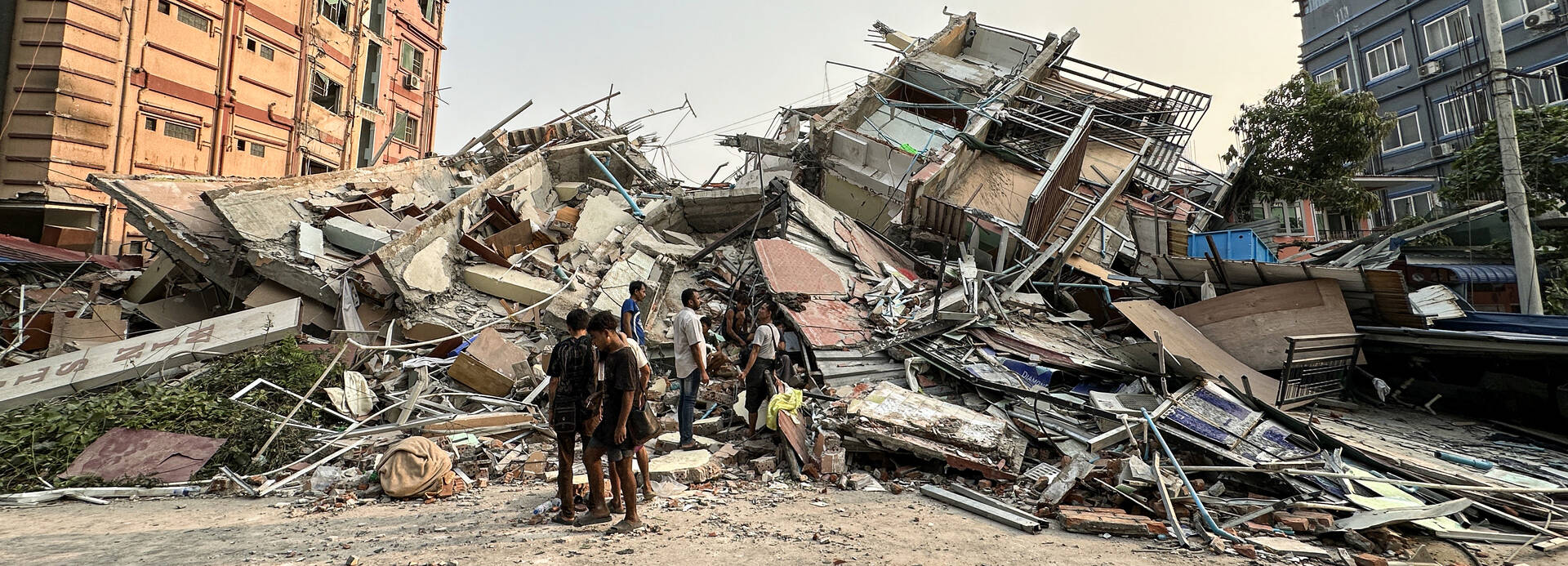 Ein schweres Erdbeben der Stärke 7,7 erschütterte am Morgen des 28.3.2025 Myanmar. Kurz darauf ereignete sich ein Nachbeben der Stärke 6,4, das die bereits entstandenen Schäden noch verschlimmerte. Menschen stehen an den Trümmern eines eingestürzten Gebäudes in Mandalay, in Myanmar, nach einem heftigen Erdbeben.
