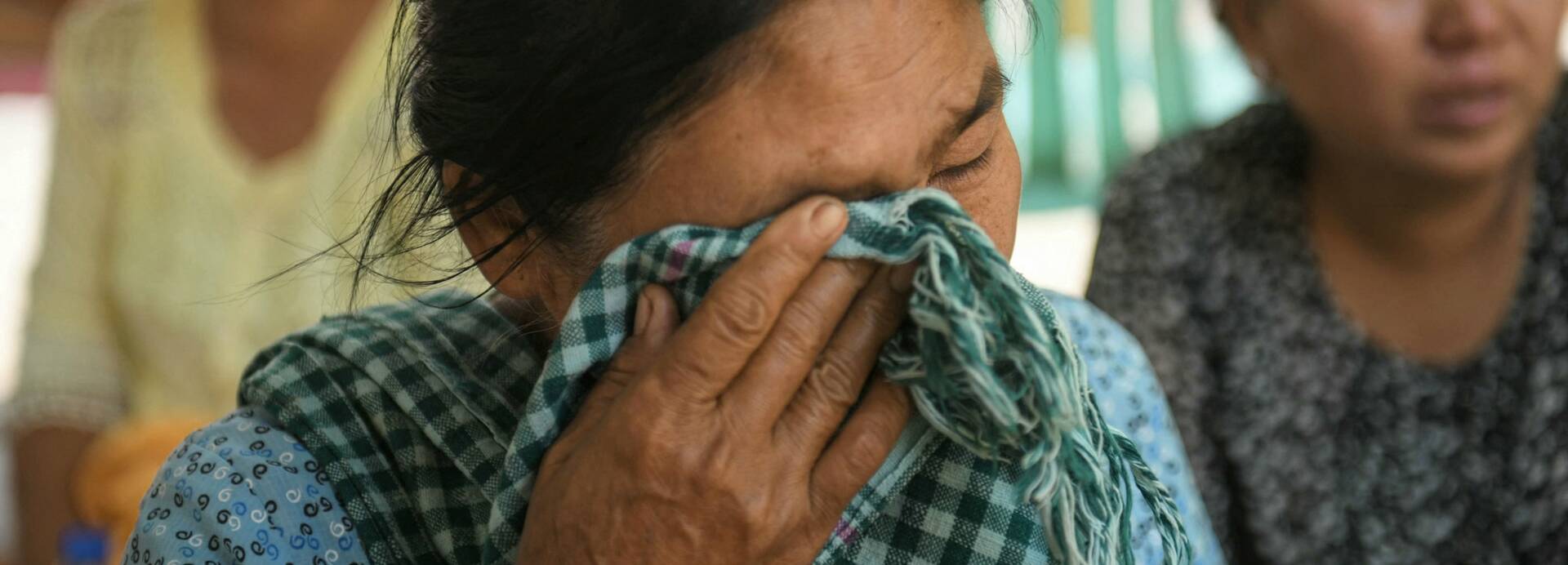Eine Frau wartet auf Ergebnisse einer Suchaktion nach Verschütteten infolge eines Erdbebens in Myanmar. Eine Frau wartet auf Ergebnisse einer Suchaktion nach Verschütteten infolge eines Erdbebens in Myanmar.