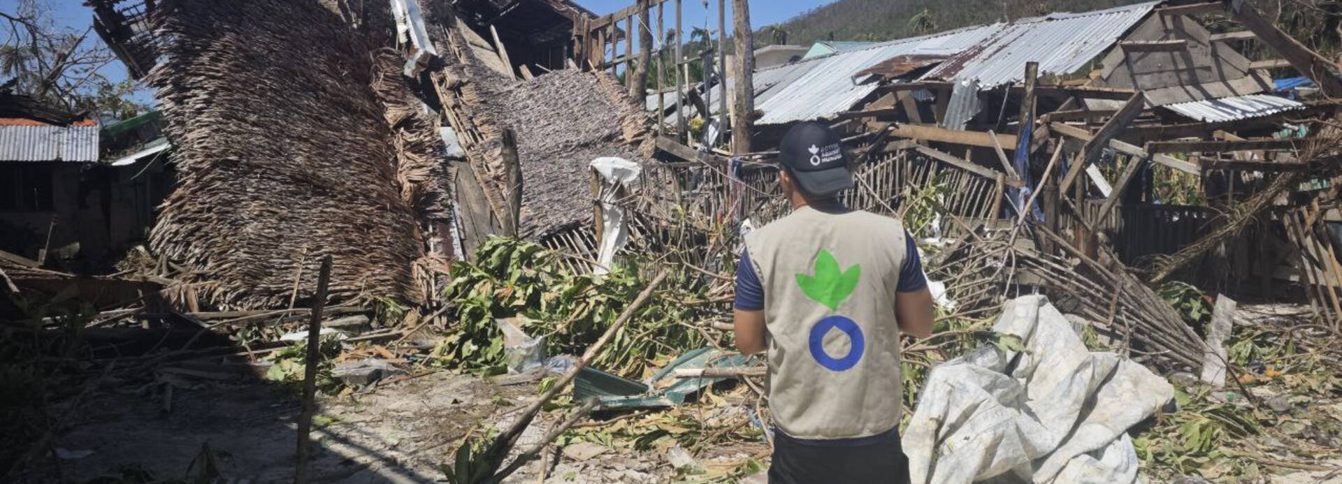 Mitarbeiter von Aktion gegen den Hunger vor zerstörten Häusern durch Taifun in Barangay Liberty, Hibisong Island, Loreto Dinagat Islands (Philippinen) Mitarbeiter von Aktion gegen den Hunger vor zerstörten Häusern durch Taifun in Barangay Liberty, Hibisong Island, Loreto Dinagat Islands (Philippinen)