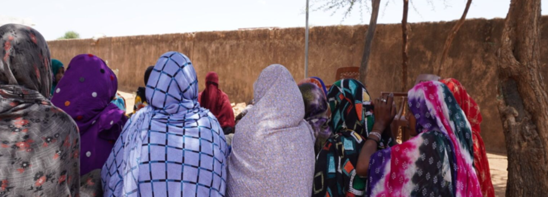 Frauen kommen in einer Selbsthilfegruppe zusammen. Rückansicht einer Gruppe von Frauen, die auf dem Boden sitzt.