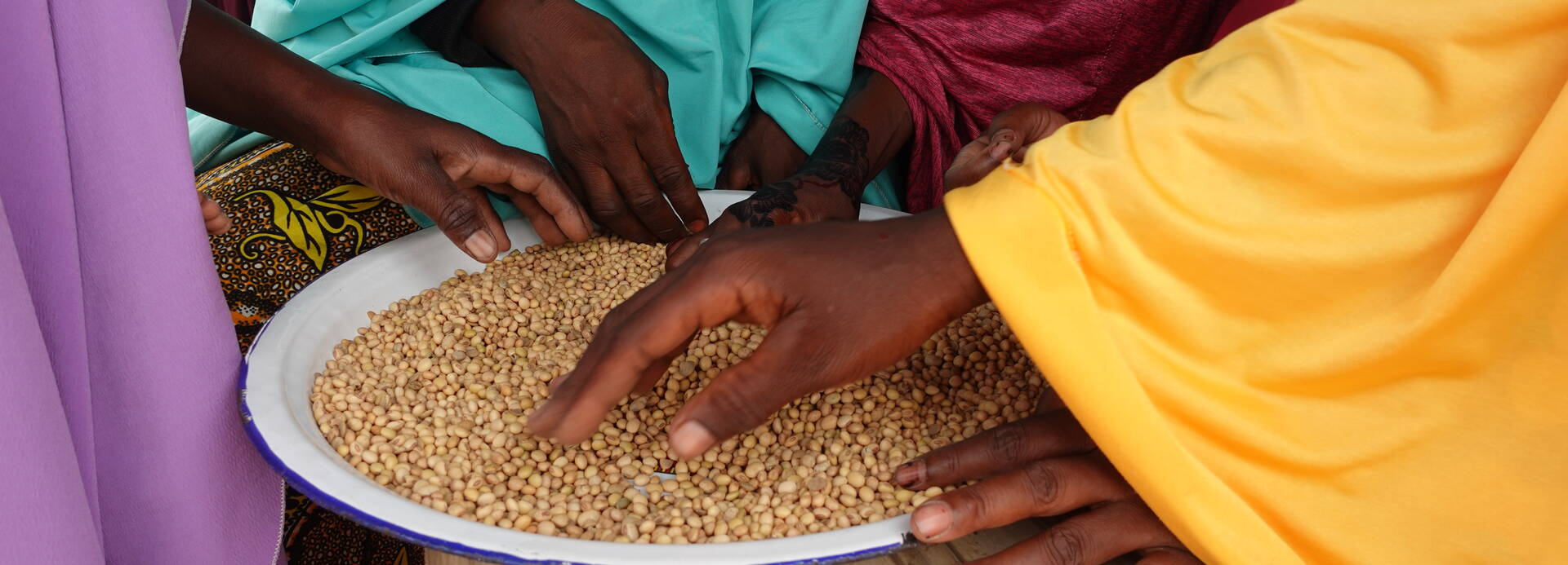 Frauen aus der Gemeinde Dabaga im Bundesstaat Sokoto, Nigeria, bereiten während einer Kochsession einen nahrhaften Brei zu, um die Genesung von Kindern zu unterstützen.