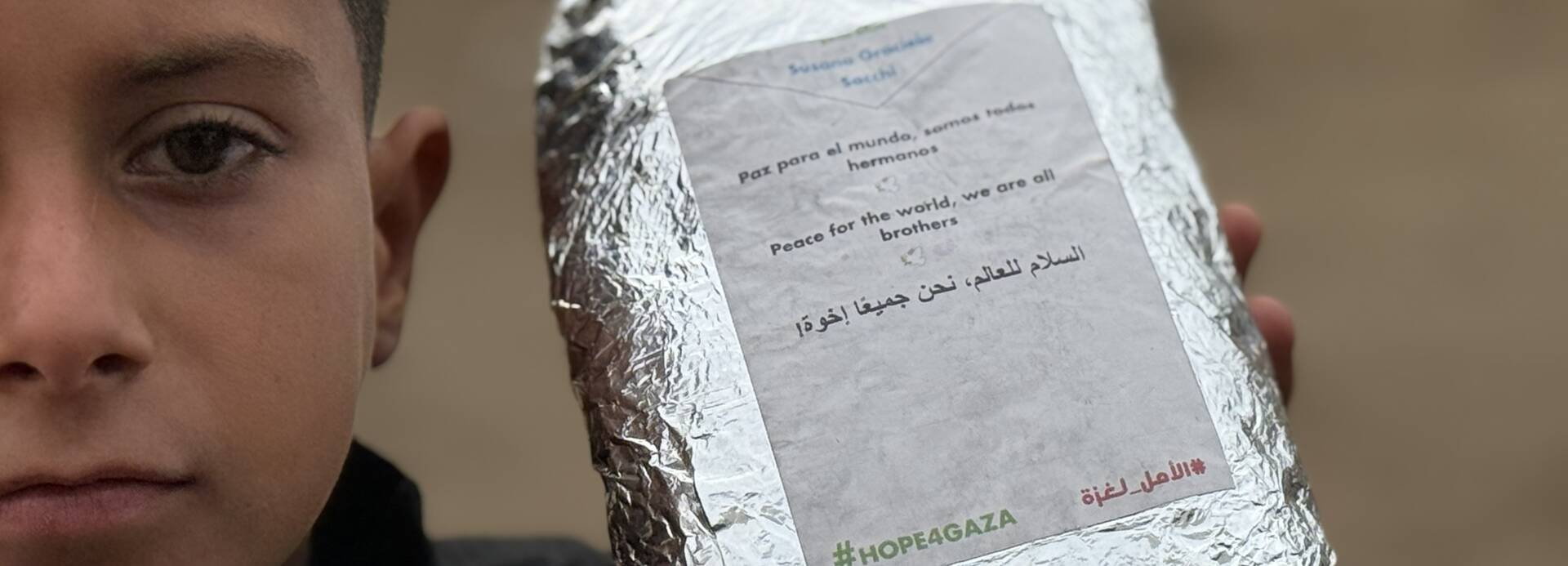Hope4Gaza: Junge hält Lebensmittelpaket mit Botschaft der Hoffnung in der Hand