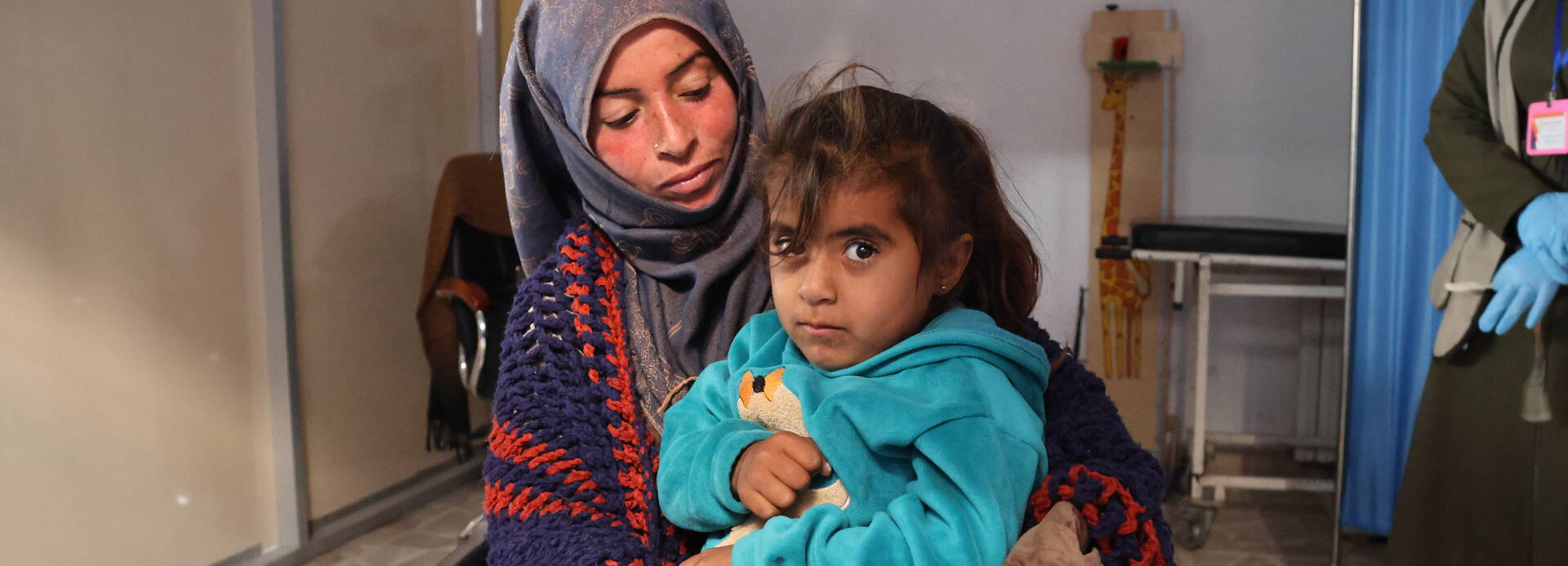 Yasmin sitzt auf dem Schoß ihrer Mutter Saadyeh im Al Sanabel Gesundheitszentrum in Syrien. 