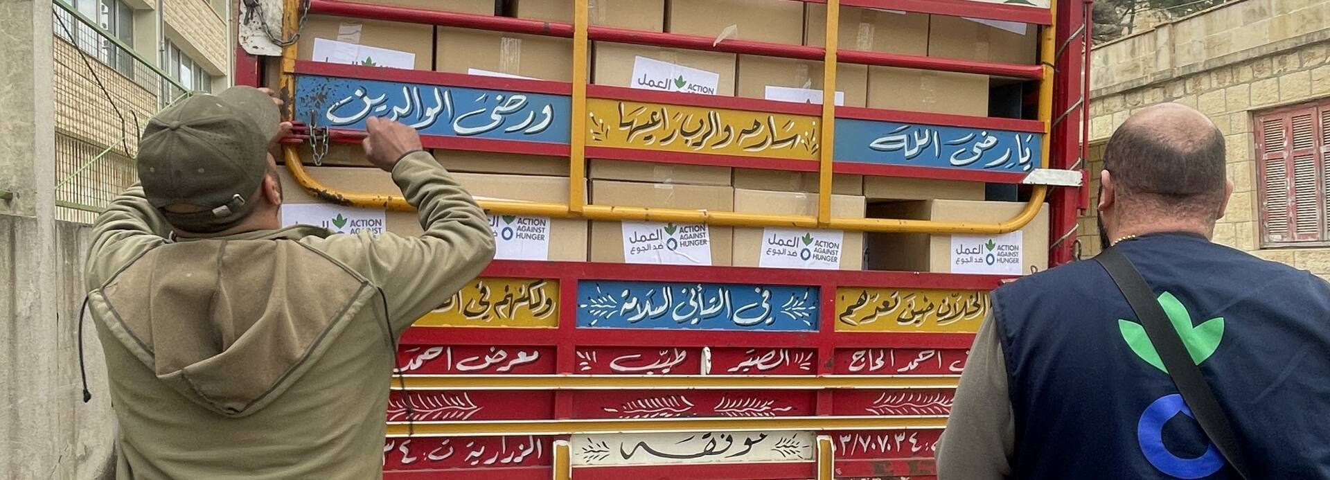 Mitarbeitende von Aktion gegen den Hunger entladen Hilfspakete im Libanon