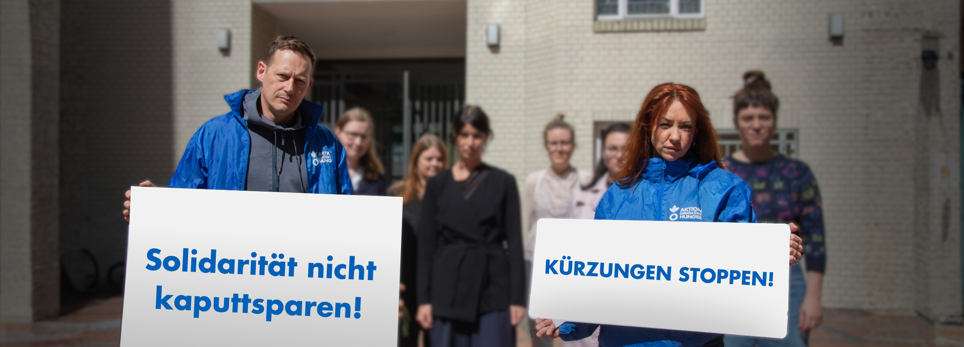 Menschengruppe hält Schilder hoch