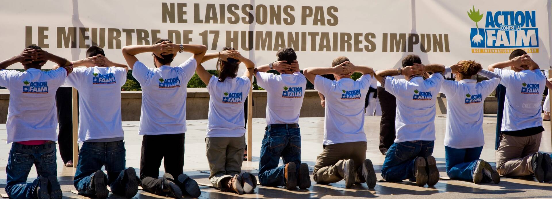 Kniende Mitarbeiter*innen von Aktion gegen den Hunger zum Gedenken an das ungesühnte Massaker an 17 humanitären Helfer*innen Kniende Mitarbeiter*innen von Aktion gegen den Hunger zum Gedenken an das ungesühnte Massaker an 17 humanitären Helfer*innen