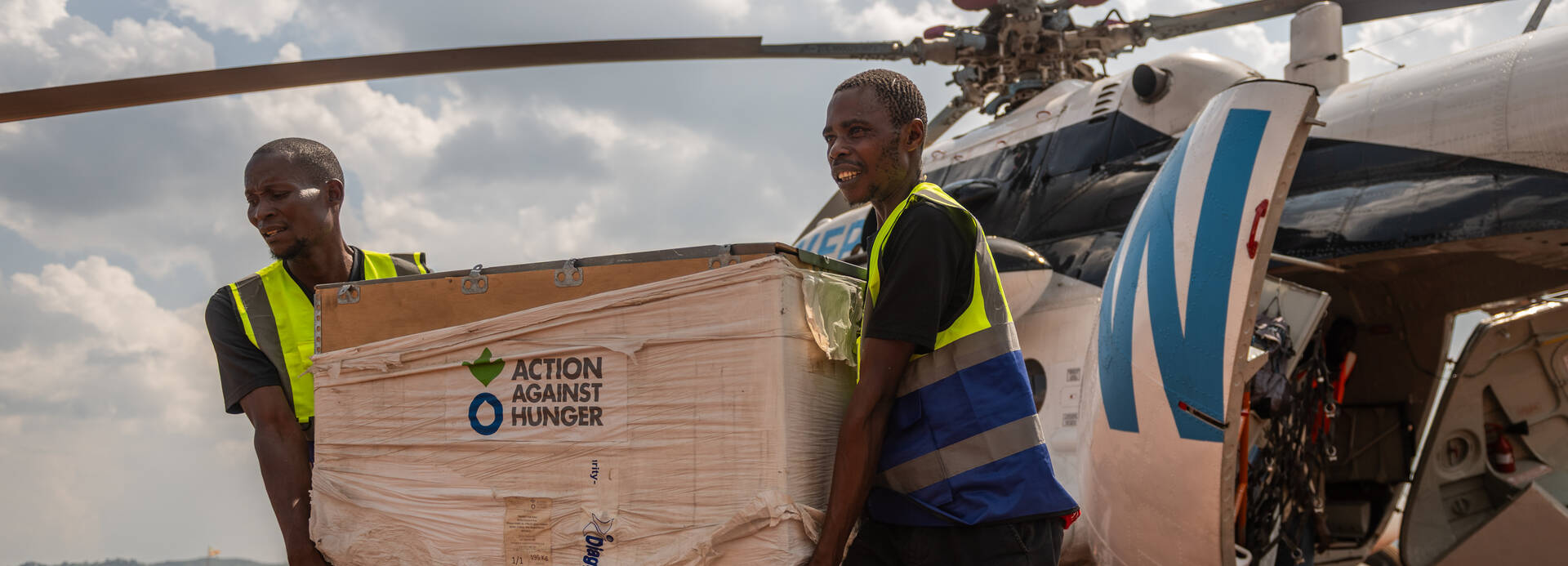 Mitarbeitende von Aktion gegen den Hunger entladen einen Helikopter mit Hilfsgütern