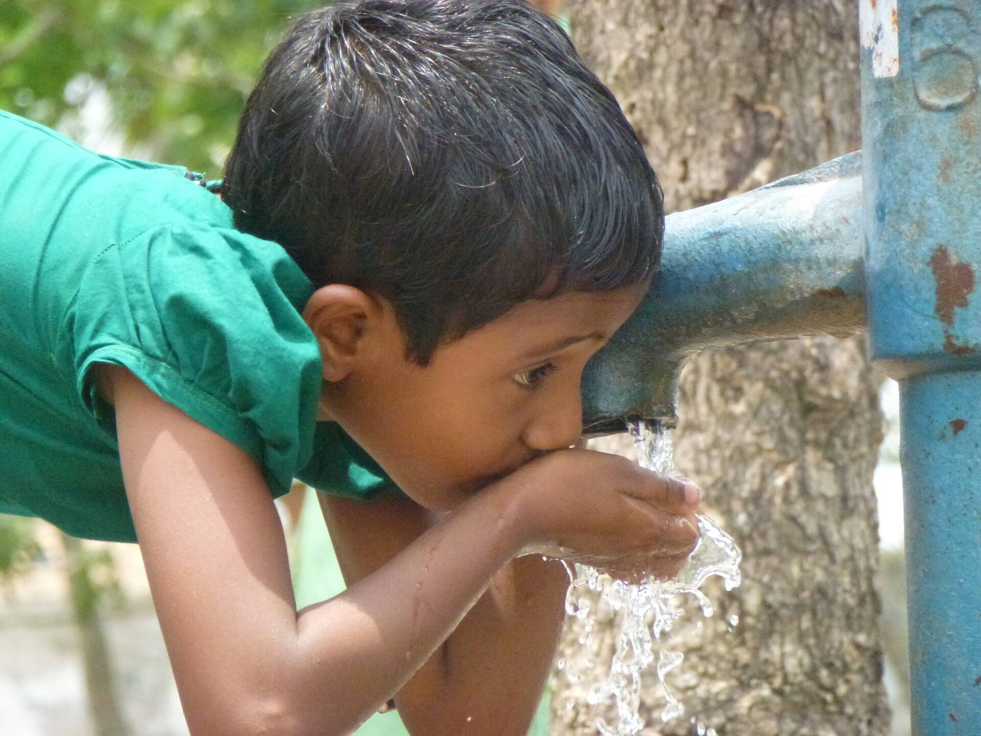 Kind trinkt Wasser aus einem Brunnen. Kind trinkt Wasser aus einem Brunnen.