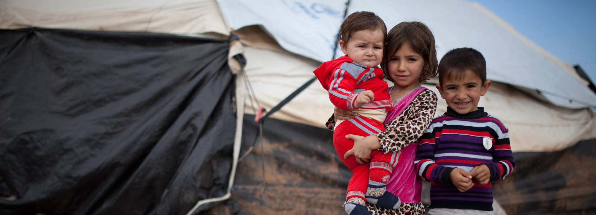 Drei Geschwister in einem Flüchtlingscamp im Irak. Sie sind vor dem Krieg in Syrien geflohen.