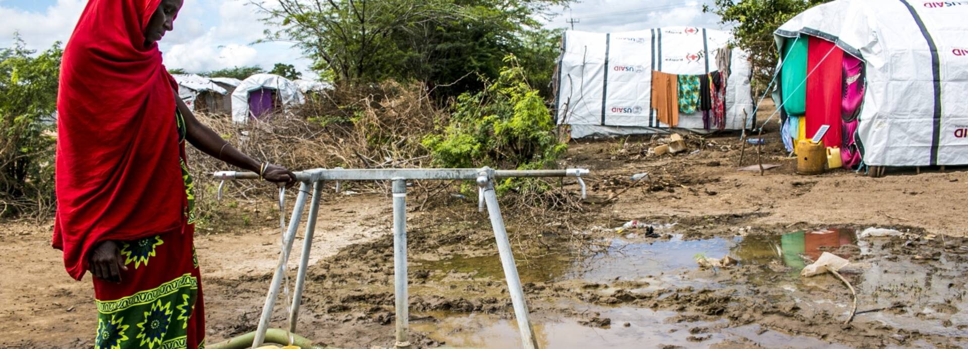 Frau füllt Kanister mit Wasser Frau füllt Kanister mit Wasser