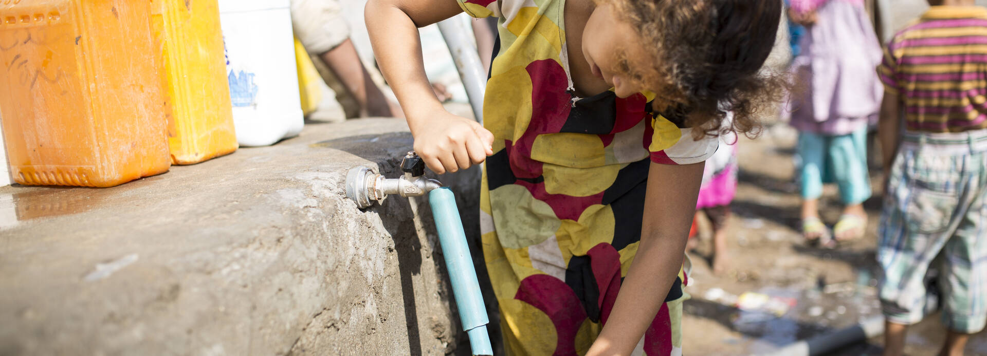 Kind aus dem Jemen füllt Wasserkanister