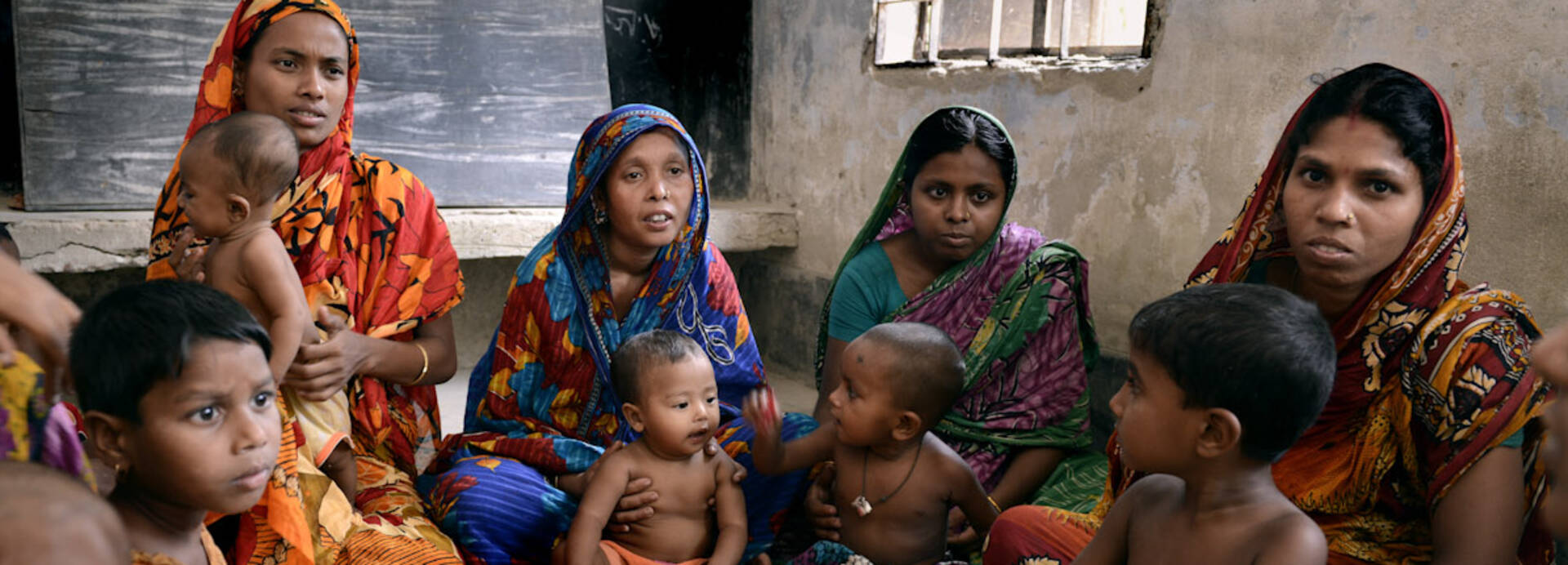 Eine Gruppe Menschen in Bangladesch sitzt zusammen im Haus.