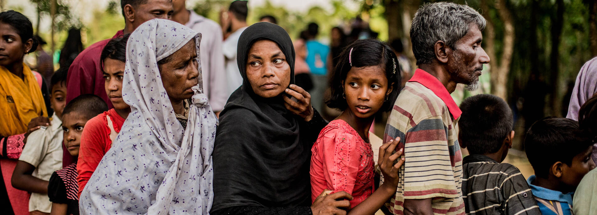 Menschen stehen in Bangladesch für etwas zu Essen in einer Reihe an.