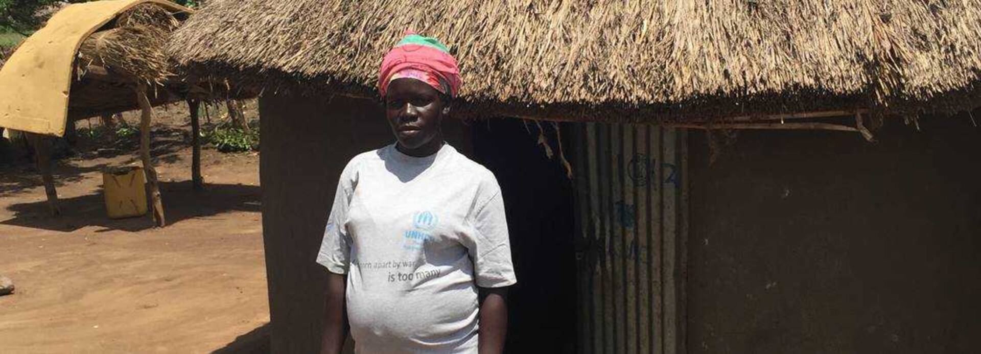 Roda steht vor ihrem Haus in Uganda.