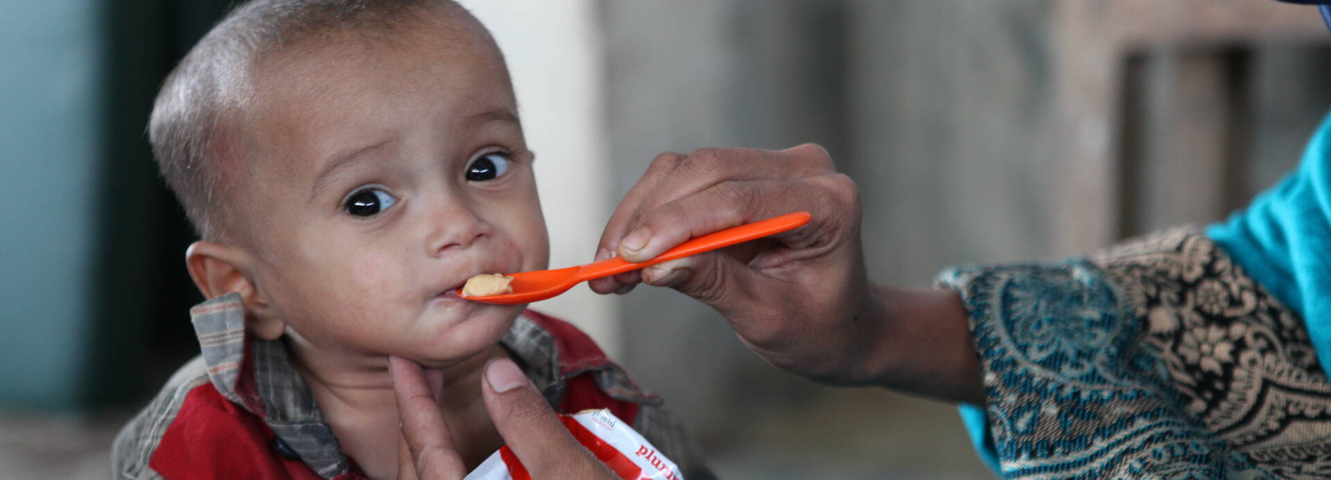 Rohingya Kind wird mit Aufbaunahrung gefüttert Rohingya Kind wird mit Aufbaunahrung gefüttert