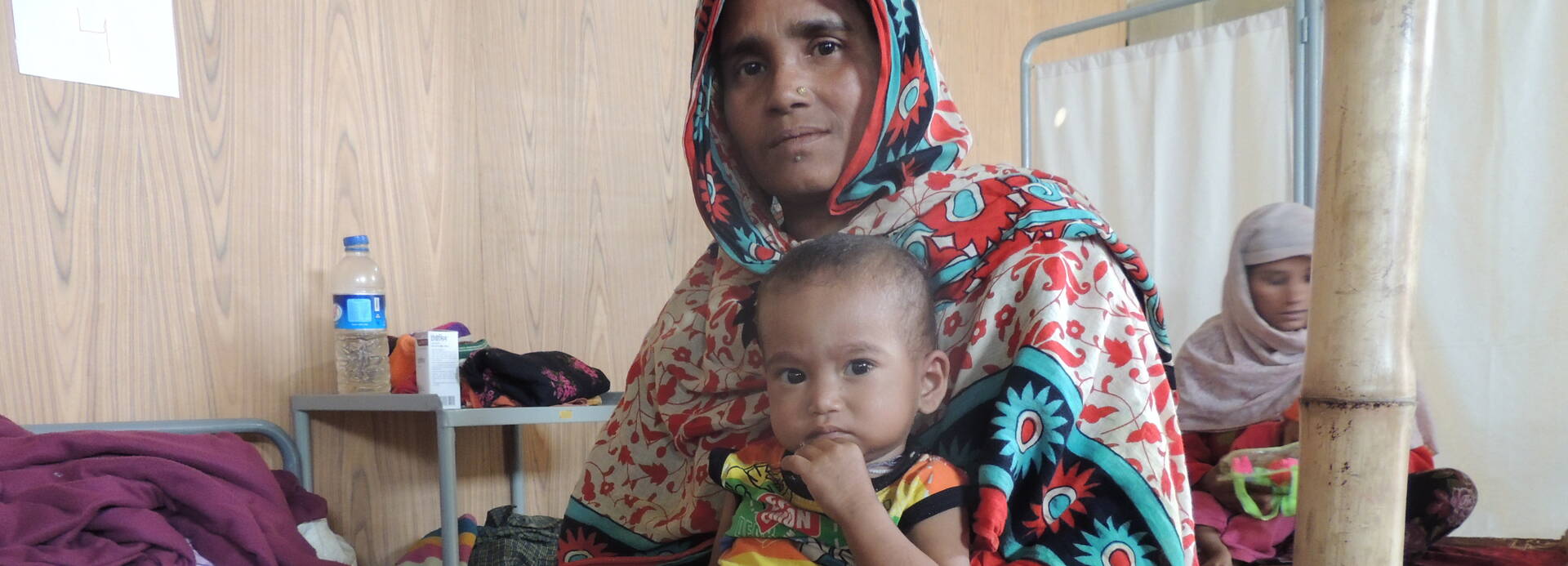 Suri mit Nila auf dem Bett einer Krankenstation in Bangladesch