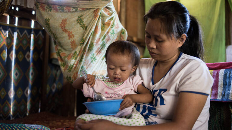 Mutter füttert ihr Kind auf den Philippinen.