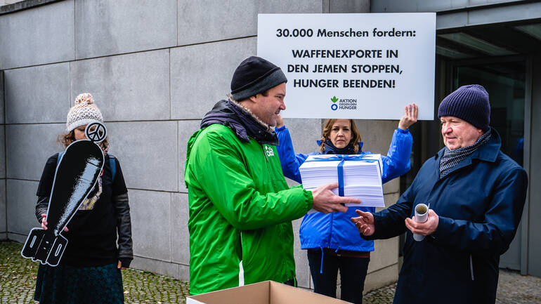 Geschäftsführer von Aktion gegen den Hunger übergibt Unterschriften an Bundeswirtschaftsministerium.