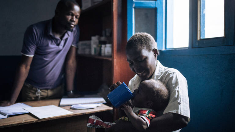 Mutter füttert Kind im Gesundheitszentrum von Aktion gegen den Hunger