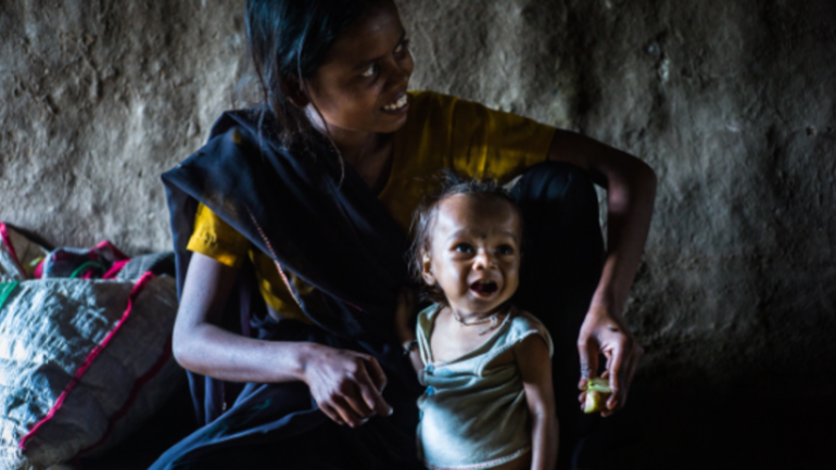 Mutter und ihr mangelernährtes Kind in Nepal fröhlich