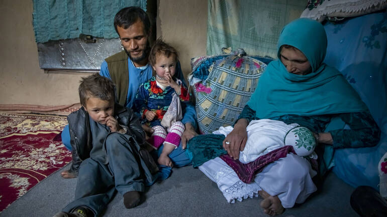 Nadia mit ihrem Mann und drei ihrer Kinder in ihrer Behausung in Daykundi