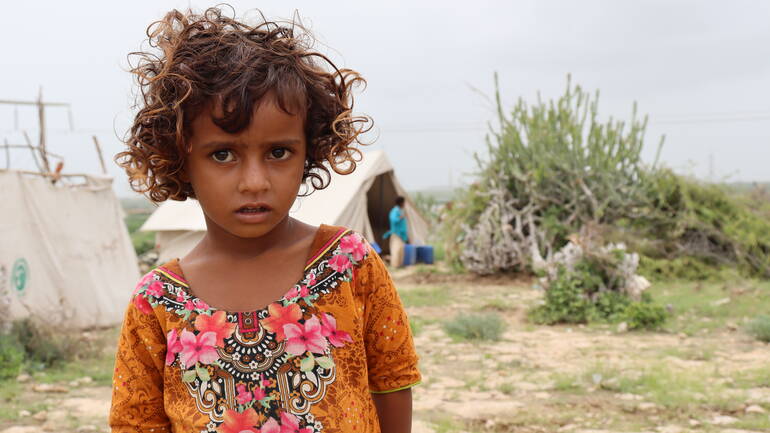 Ein kleines Mädchen vor Behelfszelten in der Region Sindh nach den Fluten in Pakistan