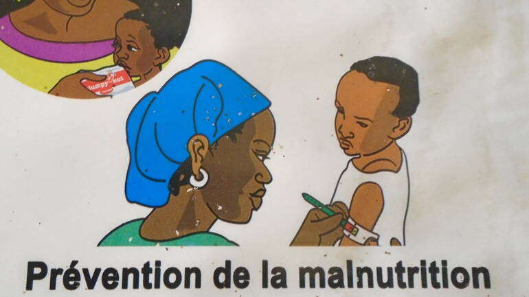 Eine Wandbemalung im Gesundheitszentrum zeigt, wie Mangelernährung bei Kindern erkannt und behandelt wird.
