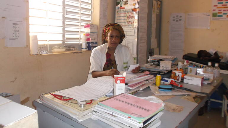 Eine Krankenschwester sitzt im Gesundheitszentrum von Touba Séras am Schreibtisch