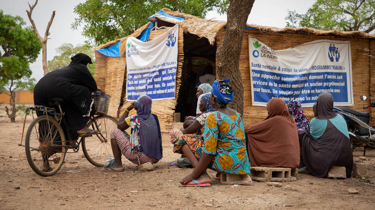 Frauen aus Burkina Faso warten vor einer Hütte von Aktion gegen den Hunger auf eine Therapiestunde