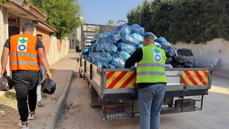 Mitarbeiter von Aktion gegen den Hunger verteilen Lebensmittel mithilfe eines Anhängers in Gaza.
