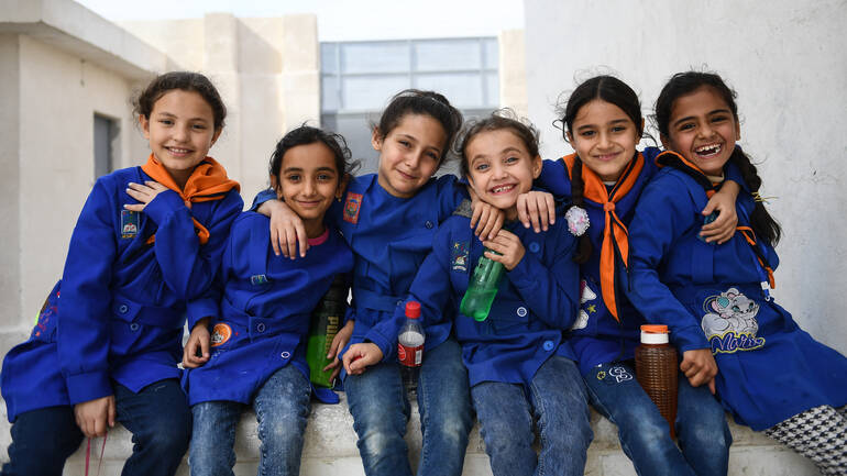 Sechs Schülerinnen der Abdulatif al-Naana-Schule in Aleppo, Syrien, strahlen - sie können wieder zur Schule gehen nach den Erdbeben 2023.
