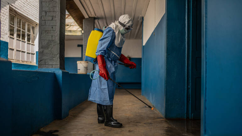 Mitarbeiter im Schutzanzug bei der Flächendesinfektion unserer Gesundheitsstation in der DR Kongo