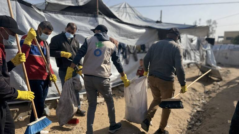 Ein Team beim Entfernen von Müll in einem Geflüchtetenlager in Gaza.