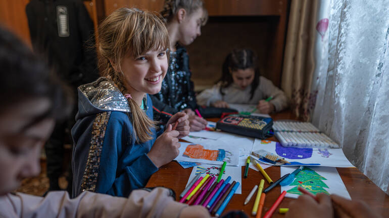Kinder malen Weihnachtsbilder in einem Heim in der Ukraine